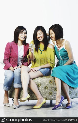 Three young women using a digital camera