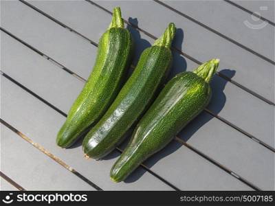 Three zucchinis after harvesting in a vegetable garden during summer