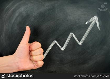 Thumb up with a positive growth arrow on a blackboard