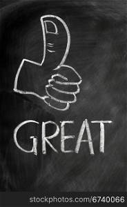 Thumb up with the word great drawn in chalk on a blackboard
