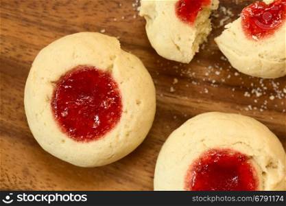 Thumbprint Christmas cookies filled with strawberry jam, photographed overhead with natural light (Selective Focus, Focus on the top of the cookies)