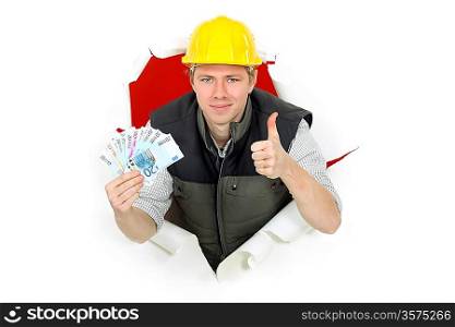 Thumbs up from a builder holding cash