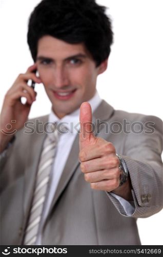 Thumbs up from a businessman on the phone