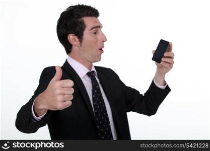 Thumbs up from a businessman with a cellphone