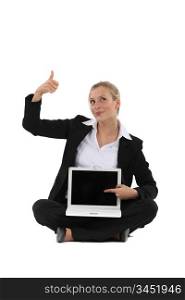 Thumbs up from a businesswoman for the blank screen on her laptop