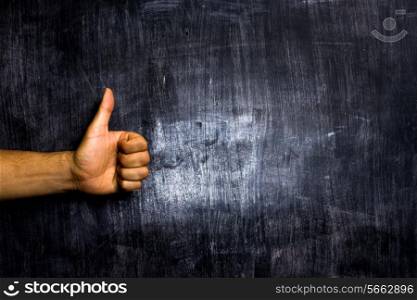 Thumbs up in front of blackboard