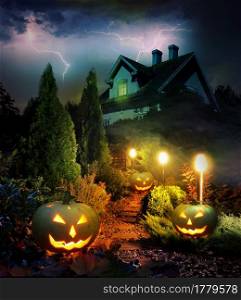 Thunderstorm on Halloween evening, pumpkin lanterns pathway throug mystery garden to scary haunted house