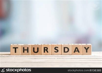 Thursday sign made of cubes on wooden planks