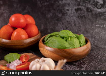 Thyme and tomatoes in a wooden cup with garlic on a wooden chopping board. Selective focus.