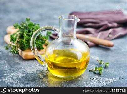 thyme oil in glass jug and on a table