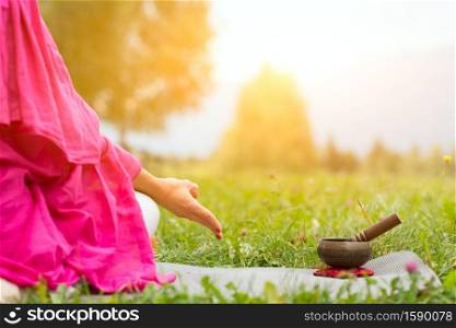 Tibetan bell beside yoga position in a meadow