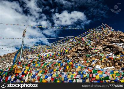Tibetan prayer flags of Buddhism with Buddhist mantra on it on top of Himalayan pass Khardung La. It&rsquo;s the highest motorable pass in the world 5602m. On the way from Leh to Nubra valley. Ladakh, India. Tibetan Buddhist prayer flags on top of Khardung La pass. Highest motorable pass in the world 5602 m