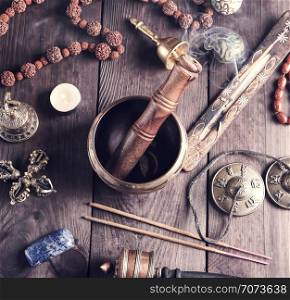 tibetan religious objects for meditation and alternative medicine on a brown wooden background, top view