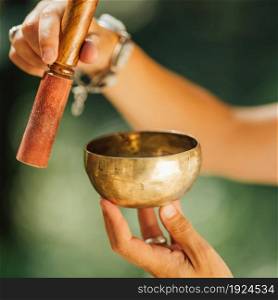 Tibetan singing bowl in sound healer hands outdoors . Tibetan Singing Bowl in Sound Healer Hands