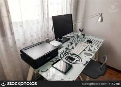 Tidy workstation with table, chair and technological devices. Workstation with table, chair, computer and printer