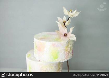 Tiered colorful wedding flower cake with wafer paper flowers with vibrant colors. Tiered colorful wedding cake with wafer paper flowers with bright colors on a stand