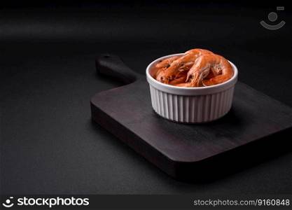 Tiger shrimp or langoustine boiled with spices and salt on a dark concrete background