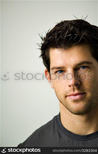Tightly cropped face shot of a young man looking into camera.