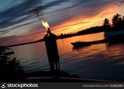 Tiki torch in-front of a lake.