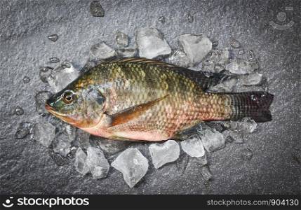Tilapia fish freshwater for cooking food in the asian restaurant / Fresh raw tilapia on ice with dark plate background