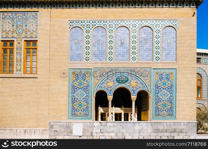 Tile art on the brick wall of Karim Khani Nook with a small marble throne inside the terrace at the Golestan palace. Tehran, Iran.