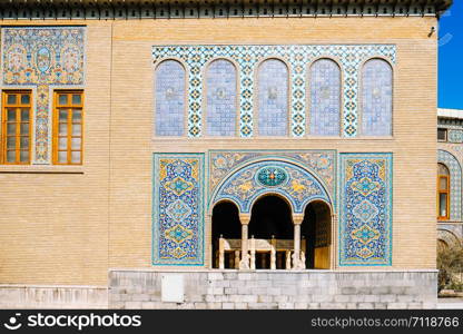 Tile art on the brick wall of Karim Khani Nook with a small marble throne inside the terrace at the Golestan palace. Tehran, Iran.