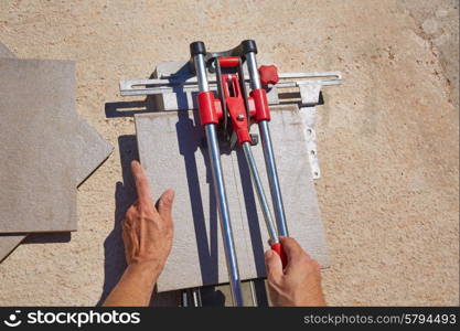 tile cutter machine with mason hands cutting tiles