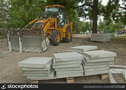 Tile paths construction with loader in park.