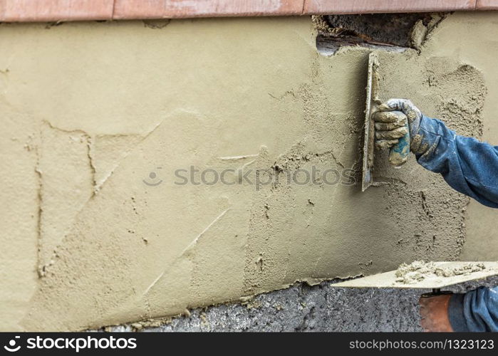 Tile Worker Applying Cement with Trowel at Pool Construction Site.