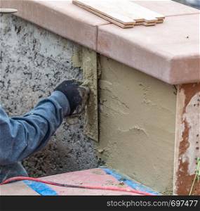 Tile Worker Applying Cement with Trowel at Pool Construction Site.
