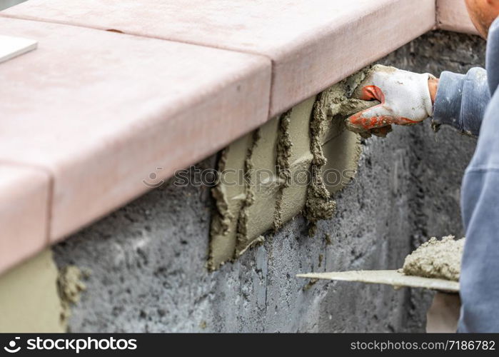 Tile Worker Applying Cement with Trowel at Pool Construction Site.