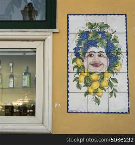 Tiled mural on wall by wine shop window, Casamicciola Terme, Campania, Italy