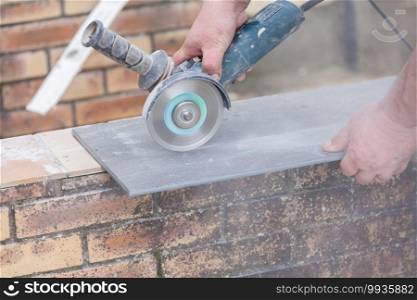 tiler cutting a tile with a grinder