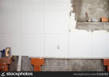 tiles white wall contruction with trowels tools and bricks