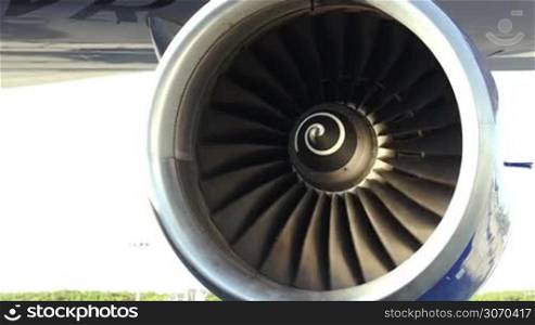 Tilt close-up shot of side engine of a plane at work