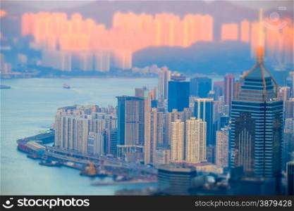 Tilt shift aerial view panorama of Hong Kong skyline and Victoria Harbor at sunset. Travel destinations