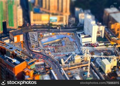 Tilt shift blur effect. Amazing aerial cityscape view with crane working at building construction. Hong Kong. Abstract futuristic cityscape with modern skyscrapers