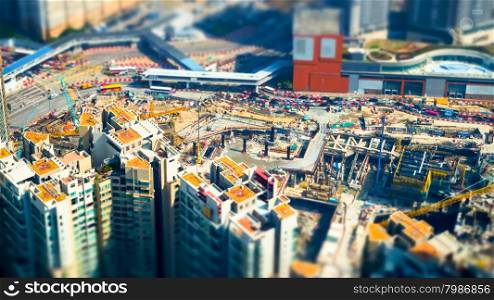 Tilt shift blur effect. Amazing aerial cityscape view with crane working at building construction. Hong Kong. Abstract futuristic cityscape with modern skyscrapers