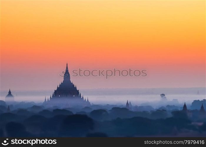 Tilt Shift blur effect. Amazing misty sunrise colors and silhouette of ancient Myauk Guni Pagoda. Architecture of ancient Buddhist Temples at Bagan Kingdom. Myanmar (Burma) travel destinations