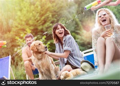 Tilt shot of family with Golden retriever enjoying summer on pier