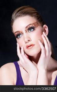 Tilted face of a beautiful dirty-blond girl with leopard print eyeshadow, isolated