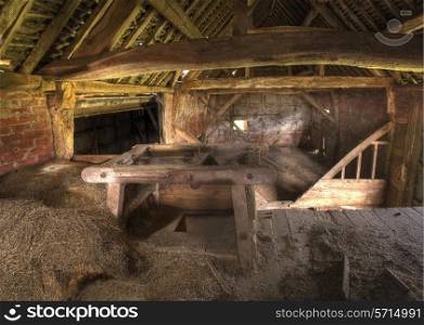 Timber-frame and brick hay barn interior, Warwickshire, England.
