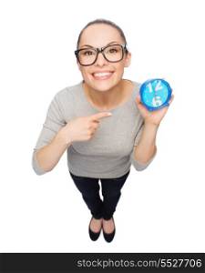 time and deadline concept - smiling woman in eyeglasses pointing to blue clock