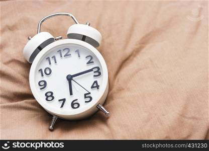 Time background concept. Alarm clock on bed, wake up in the morning. Picture for add text message. Backdrop for design art work.