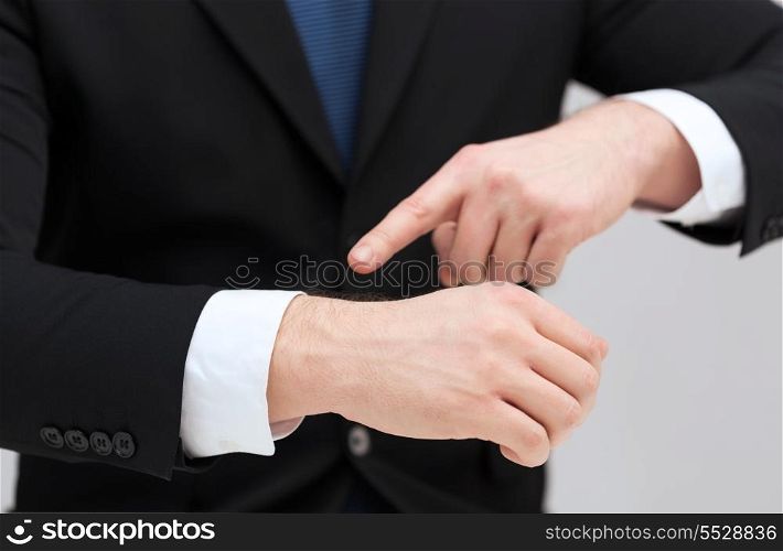 time, business and new technology concept - close up of businessman pointing to something at his hand
