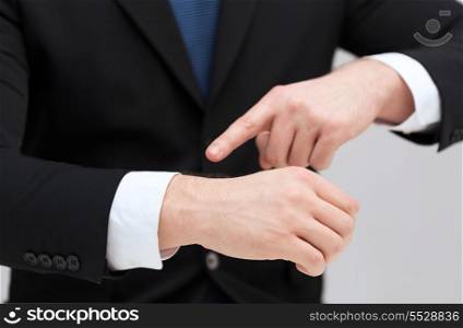 time, business and new technology concept - close up of businessman pointing to something at his hand