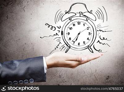 Time concept. Close up of businesswoman holding alarm clock in palm