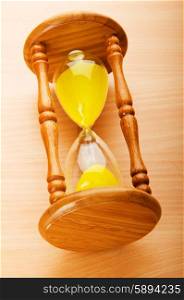 Time concept - hourglass against the wooden background