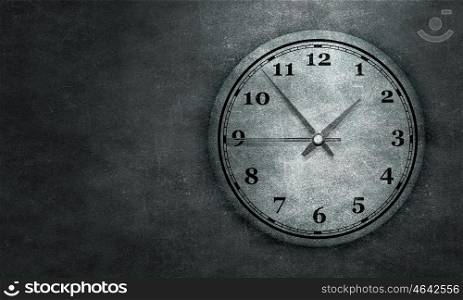 Time concept on cement wall. Round wall clock hanging on grey concrete wall