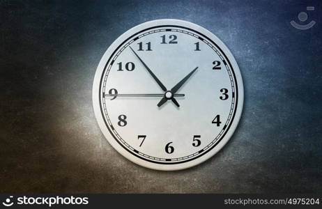 Time concept on cement wall. Round wall clock hanging on grey concrete wall